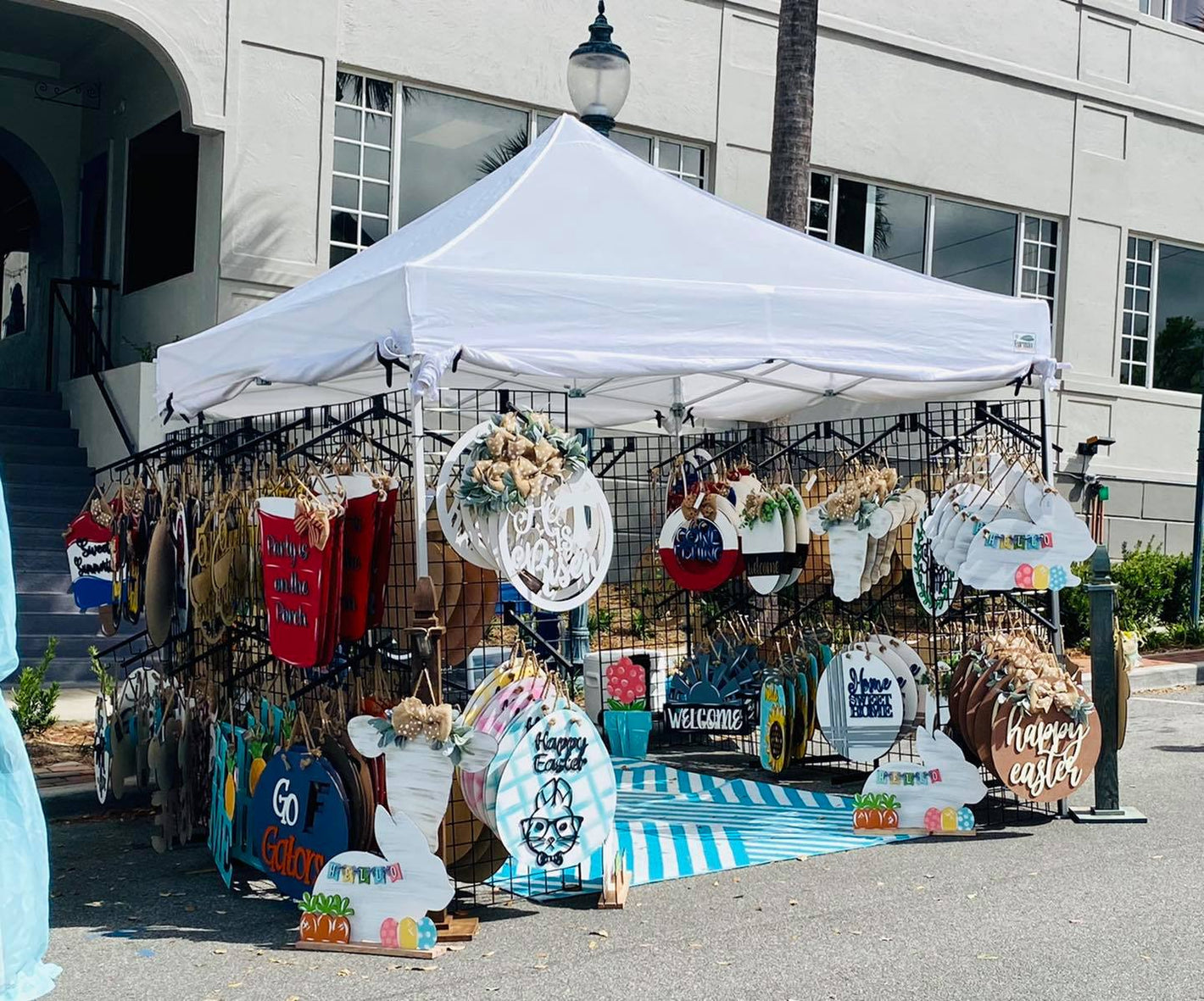 The Personalized Peach’s tent set up with door hangers, porch signs, and other hand painted home decor ready to sell at a vendor event in Cocoa, FL